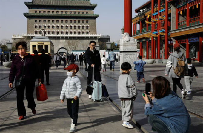Du khách chụp ảnh tại quảng trường Thiên An Môn, Bắc Kinh. Ảnh: Reuters
